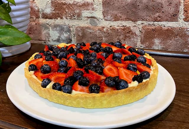 Fruit flan, topped with fresh strawberries and blueberries.